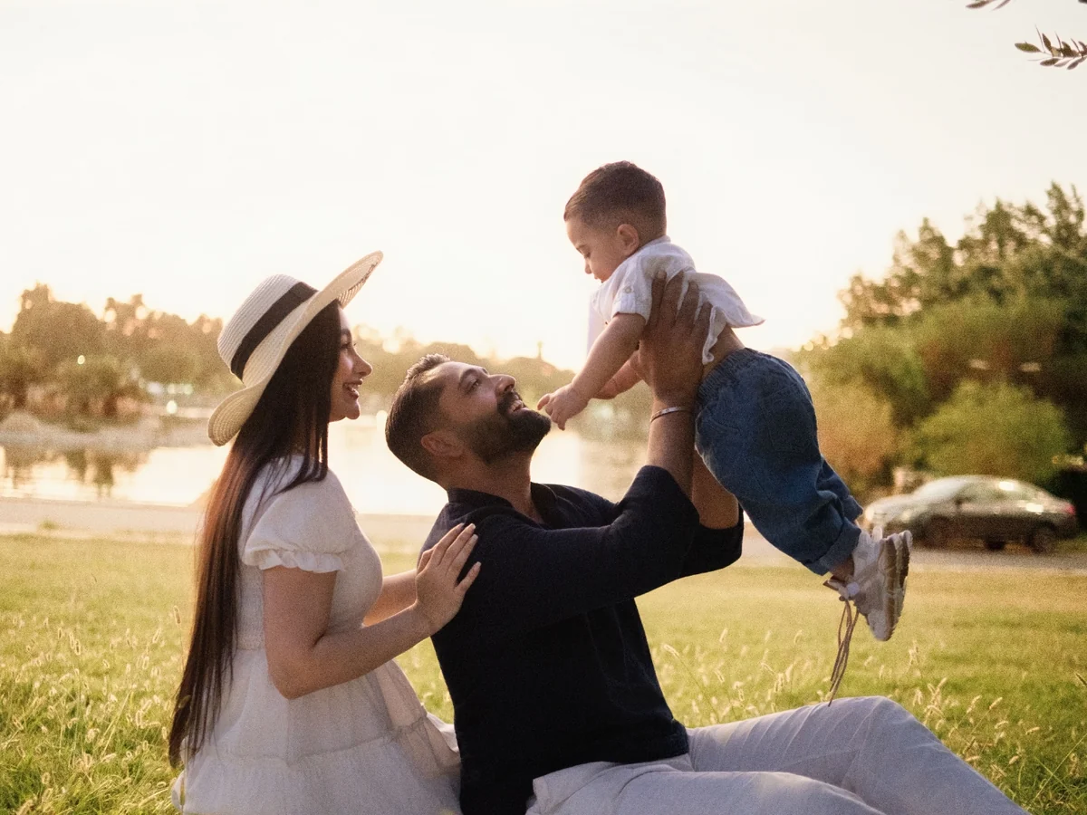 A young family together outdoors at sunset